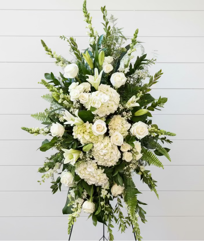Bouquet of white flowers with greenery against a wooden background